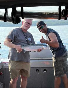 A rainbow trout being held by two people in Minnesota