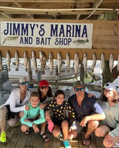 Fresh caught fish displayed at Jimmy's Marina and Bait Shop in Port Isabel TX with fishing group celebrating successful charter trip