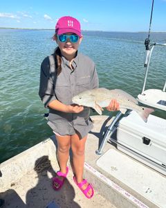 A fisherman holds a 17-inch redfish in Port Isabel