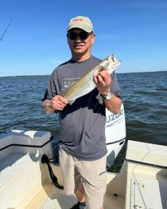 A person fishing in NC with a single fish