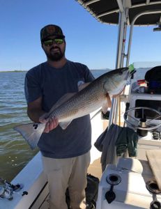 A fisherman holding a large redfish in NC.