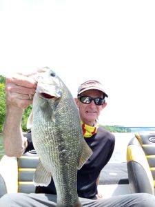 A solo angler holding a spotted bass from Cleveland