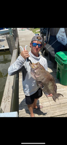 A person fishing in Biloxi with a 17-inch catch
