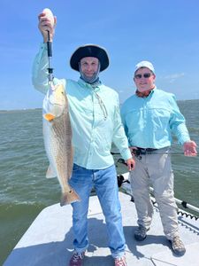 Angler holding a large redfish caught in Aransas Pass