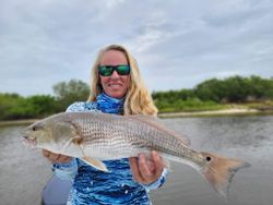 A fisherman with a large redfish caught in Hernando