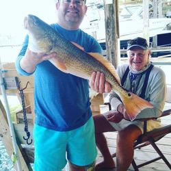 Fishing Duo Reeling in a Catch at Port Isabel