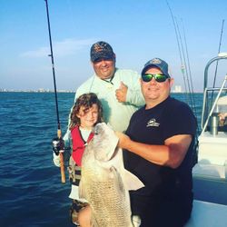 Three anglers stand in a field in TX catching fish.