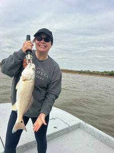 Freshly caught redfish held up on fishing boat in Matagorda TX waters
