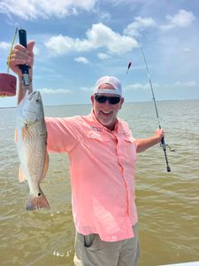 Successful redfish catch in Matagorda TX waters with fishing rod and pliers