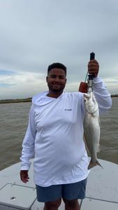 Angler holding a spotted weakfish catch in Matagorda, Texas