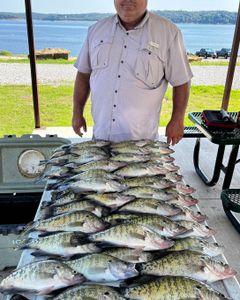 A fisherman holding 8 white crappie fish in OK
