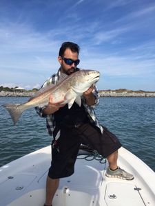 A fisherman catching a redfish at New Smyrna Beach