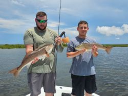 Two redfish caught by two people in Spring Hill