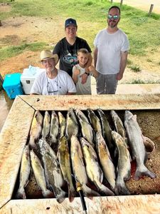 Successful fishing trip in Elmendorf TX showing multiple fish species laid out on cleaning table