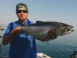 Fisherman holding a 22-inch catch on a pier in Ontario, Canada