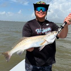 A fisherman holds a spotted weakfish in Matagorda