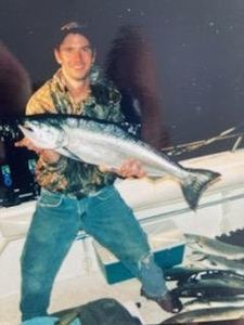 Angler posing with a large fish caught in Mackinaw City