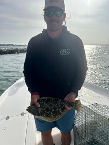 A summer flounder fish measuring 12 inches caught by a person in Orange Beach