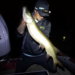 A lone angler fishing in Mosinee, holding a 26-inch catch