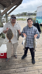 Anglers enjoying a productive day on the water, reeling in a variety of summer flounder and spotted weakfish.