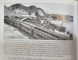 Historic black and white photograph showing train station with passengers boarding train near mountains in Yuma Arizona