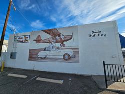 Historic mural on Fowler Building in Yuma AZ featuring vintage airplane and classic car