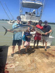 Four people fishing for two large fish in Falmouth