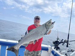 Fisherman catches a chinook salmon at 990 Point Breeze Road