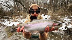 Angler holding a large rainbow trout in Angola