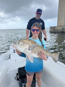 Photo of two people fishing for a black drum fish in Florida