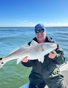 "Triumphant catch of the day against a serene, oceanic backdrop."