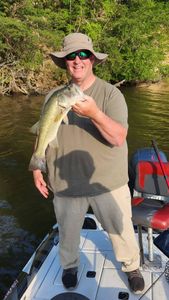 Angler holding freshly caught bass on fishing boat in King George VA