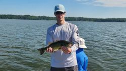 Angler holding freshly caught bass on lake in King George VA