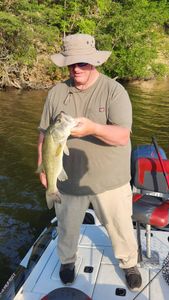 Angler holding caught bass fish on boat in King George VA waterway