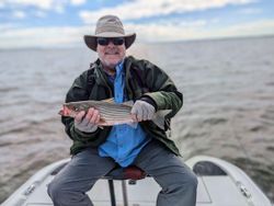 A single fisherman holding a 12-inch catch in King George