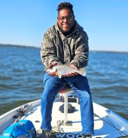A single fisherman catching a 11-inch fish in King George