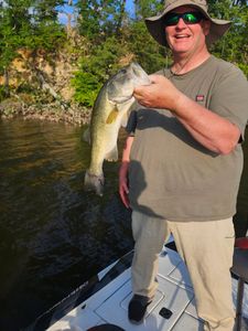Angler holding caught bass fish on boat in King George VA