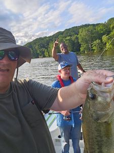 Bass caught while fishing on lake in King George VA with forested shoreline