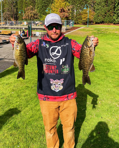 Angler holding two smallmouth bass in Port Orchard