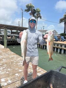 Two redfish caught in Port O'Connor Texas fishing trip displayed at marina dock