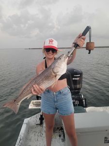 A fisherman holding a large redfish in Port O'Connor