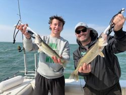 Two anglers displaying freshly caught walleye on fishing boat in Port Clinton OH waters