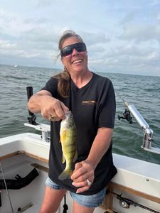 A person stands at the waterfront in Port Clinton, enjoying cruises, fishing, and tours.