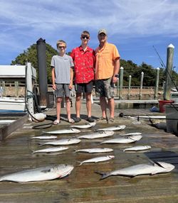 Successful fishing trip in Norfolk VA showing catch of bluefish and king mackerel laid out on marina dock