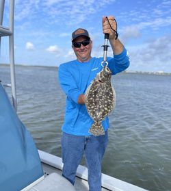 A fisherman reels in a Southern Flounder in Corpus Christi