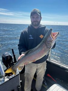 Angler holding a large lake trout caught while fishing at Sackets Harbor