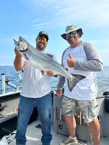 Angler catching a large Chinook Salmon in Sackets Harbor