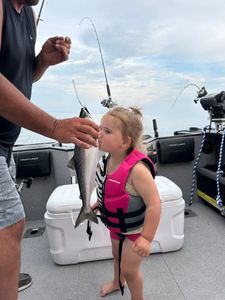 Child holding freshly caught fish on fishing boat in Sackets Harbor NY