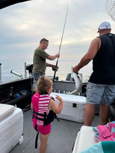 Fishing boat on water with caught fish being handled during fishing trip in Sackets Harbor NY