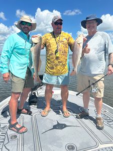 Two redfish caught by three people in TX